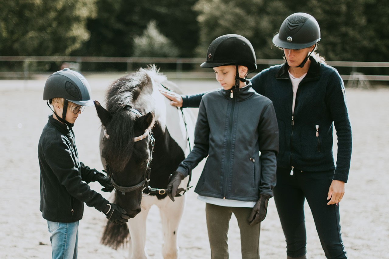 Trygga ledare – Två barn tillsammans med en ledare och en häst.