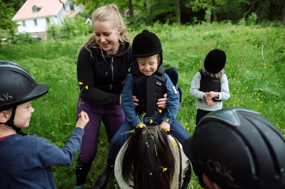 ledare hjälper barn på hästryggen