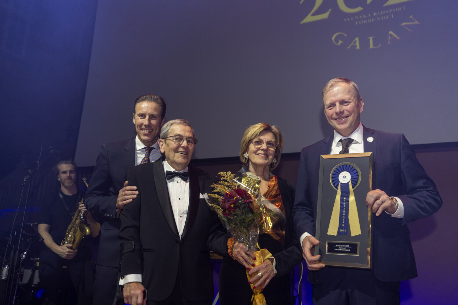 Ett stolt team kring Markan Cosmopolit tar emot utmärkelsen Årets Häst på Ryttargalan 2023. Prisutdelare var Johan Fyrberg, tillträdande generalsekreterare.